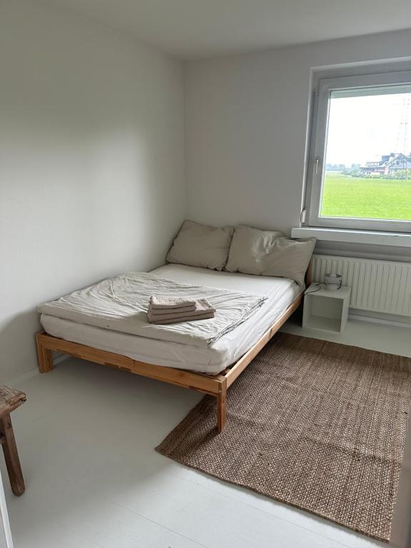 a bed in a white room with a window at Casa Móre SMALL in Niederalm