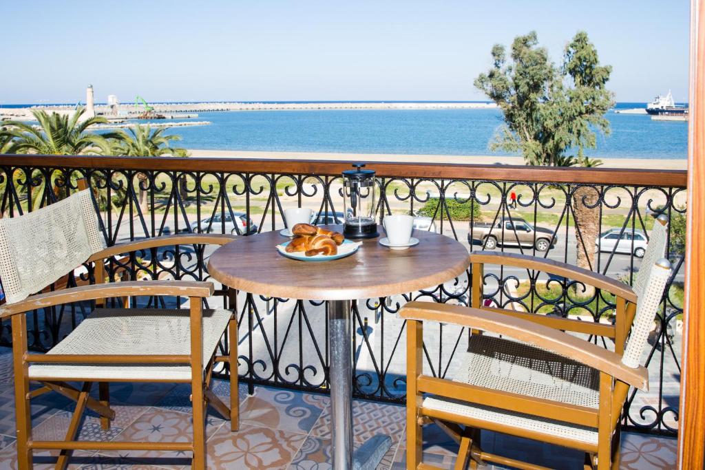 a table with a plate of food on a balcony at Prokymaia Penthouse Apartment in Rethymno