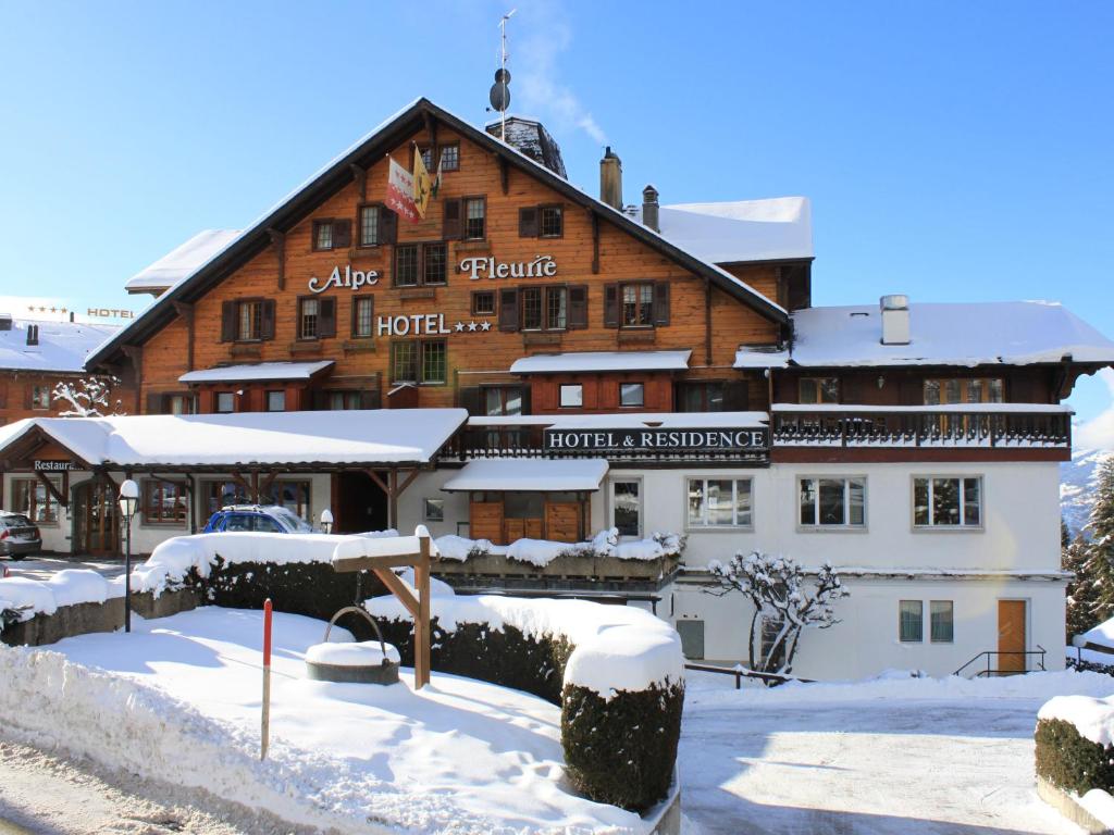 a large wooden building with snow on the ground at Alpe Fleurie Hôtel & Restaurant in Villars-sur-Ollon