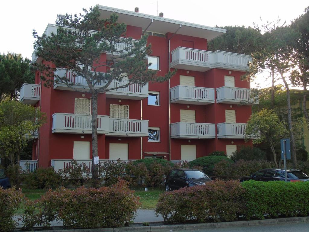 リニャーノ・サッビアドーロにあるCondominio Nazioniの赤いアパートメントで、白いバルコニーが付いています。