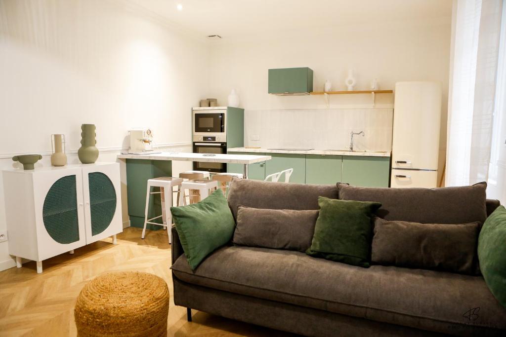 un salon avec un canapé et une cuisine dans l'établissement L'Olivier de Beau Pré - App 1-2 - Centre ville, à Perpignan