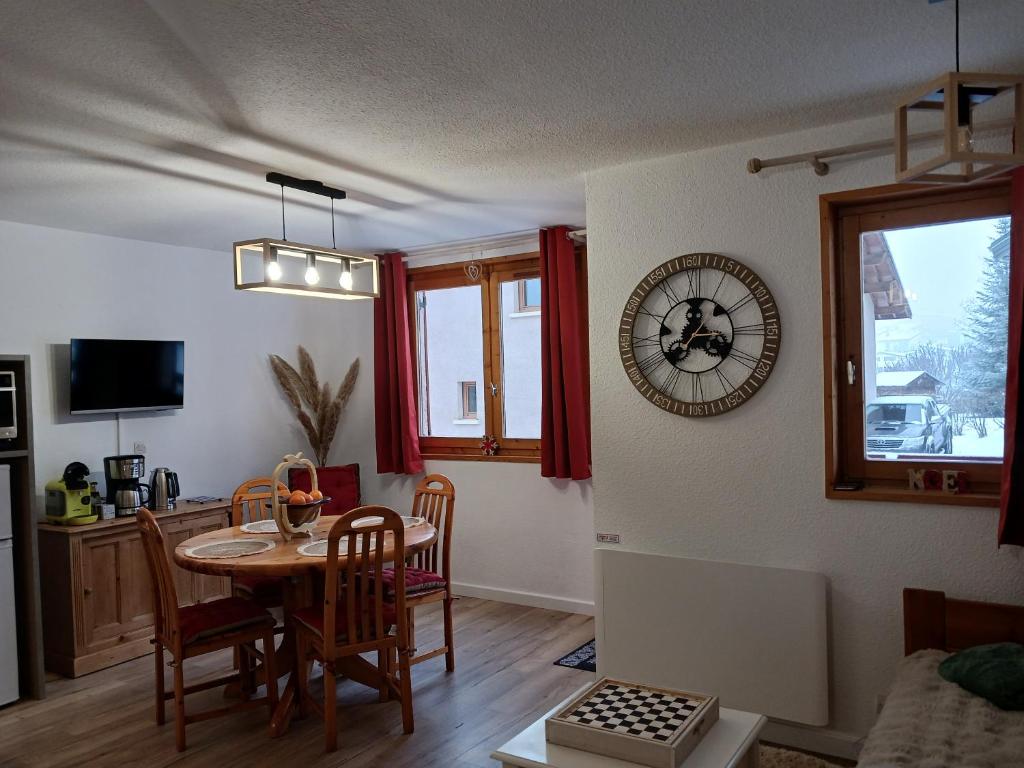 - un salon avec une table et une horloge murale dans l'établissement Aussois 4 personnes, à Aussois