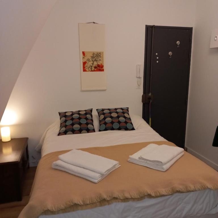 une chambre avec deux lits avec des serviettes dessus dans l'établissement Charming room - famous Marais neighborhood, à Paris