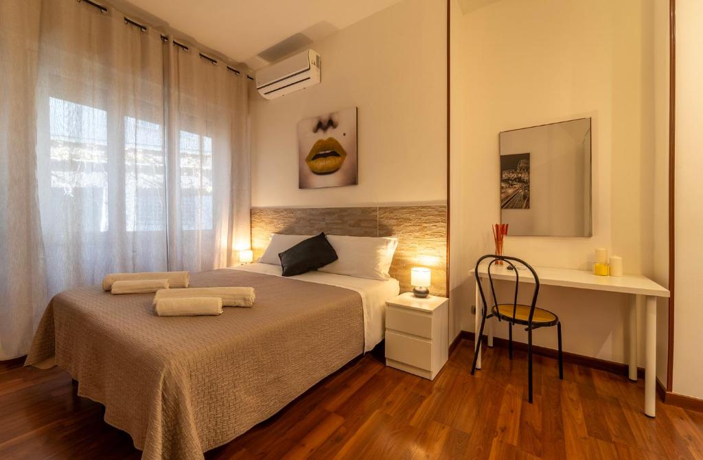um quarto com uma cama, uma secretária e uma janela em MAGICFIVEROOMS di ANISA em Roma