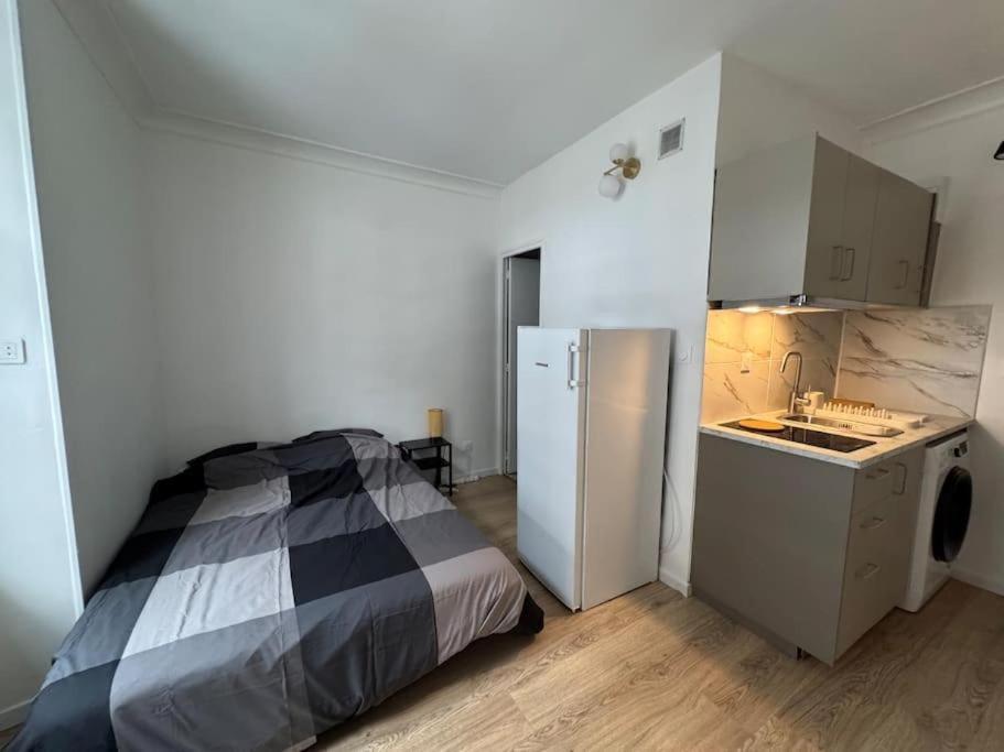 Il comprend une chambre avec un lit et une cuisine équipée d'un réfrigérateur. dans l'établissement Studio Cosy 1 Chambre Proche Paris & Versailles, à Les-Loges-en-Josas