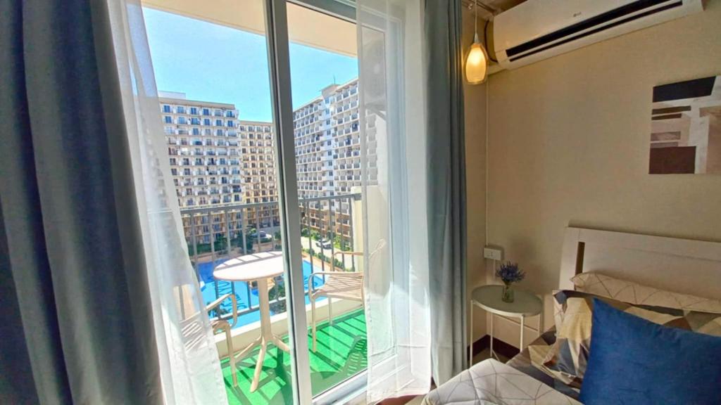 a bedroom with a large window with a view of a building at Condo in Lapu-Lapu City in Suba