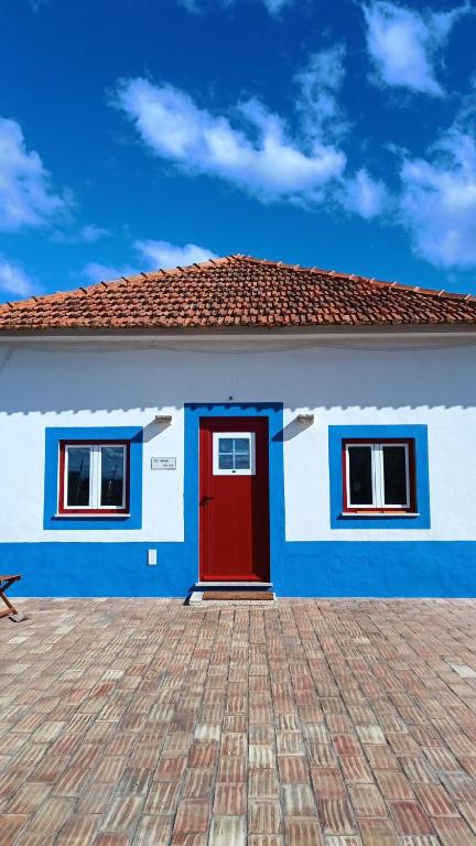 a blue and white house with a red door at Pátio da Eira, Country House in Chamusca