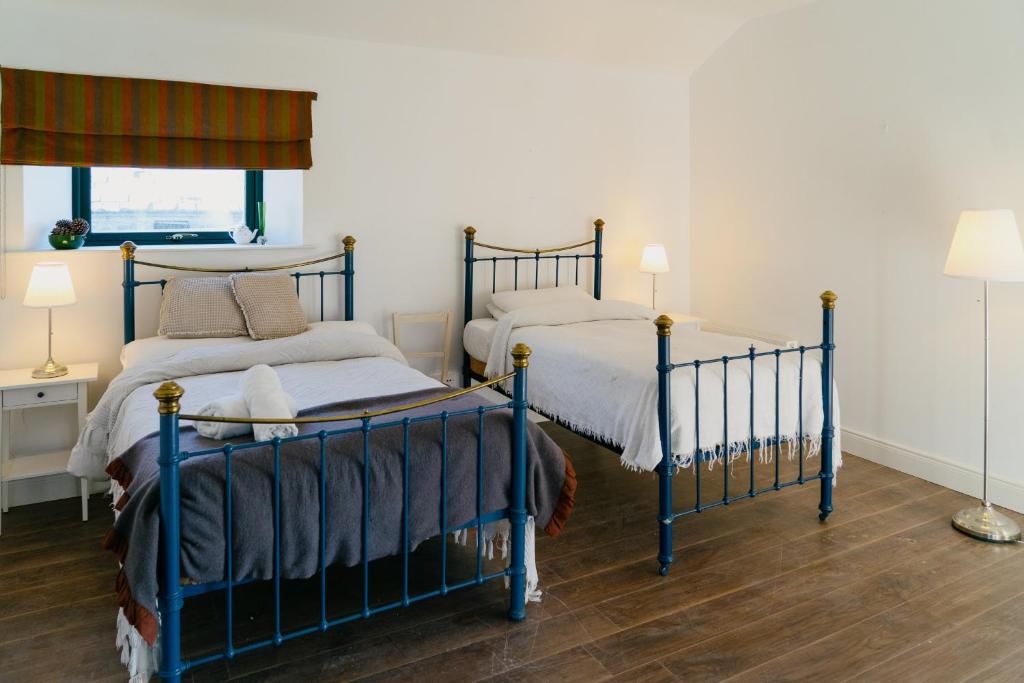 a bedroom with two beds and two lamps in it at The Coach House at Ballinderry Park in Ballinasloe