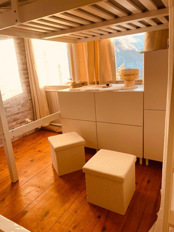 une chambre avec deux tabourets et une chambre avec une fenêtre dans l'établissement Chez So Orcieres, à Orcières