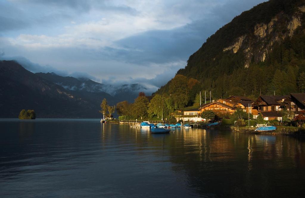 un cuerpo de agua con casas y barcos en él en Family-Apartment Du Lac, en Iseltwald