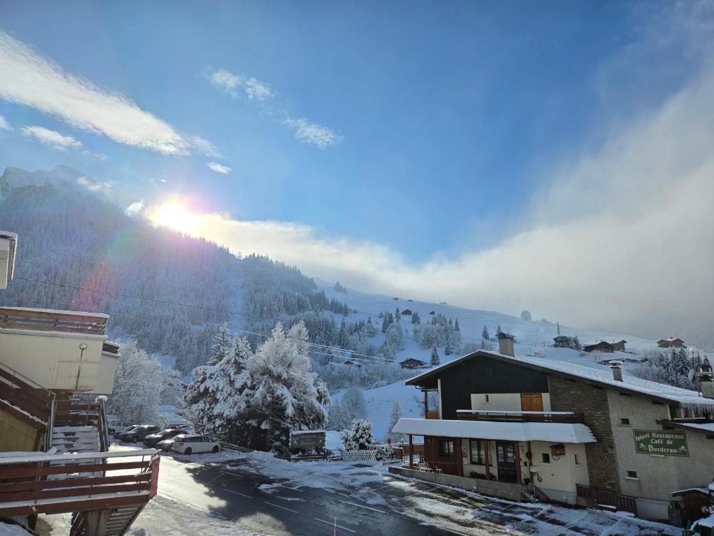 une montagne enneigée avec le soleil en arrière-plan dans l'établissement Pied des pistes app 5 personnes, à La Clusaz
