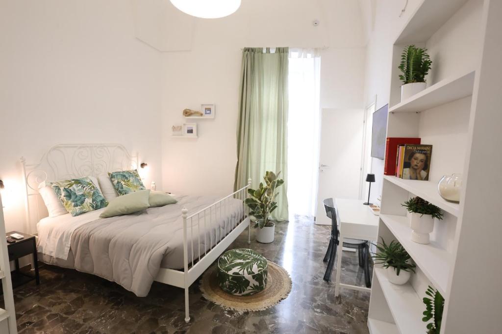 a white bedroom with a bed and a desk at Casa Alessandra in Nardò
