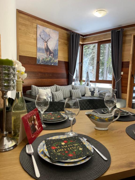 ein Esstisch mit Tellern und Weingläsern in der Unterkunft Elizi1winter apartments Pamporovo in Pamporowo