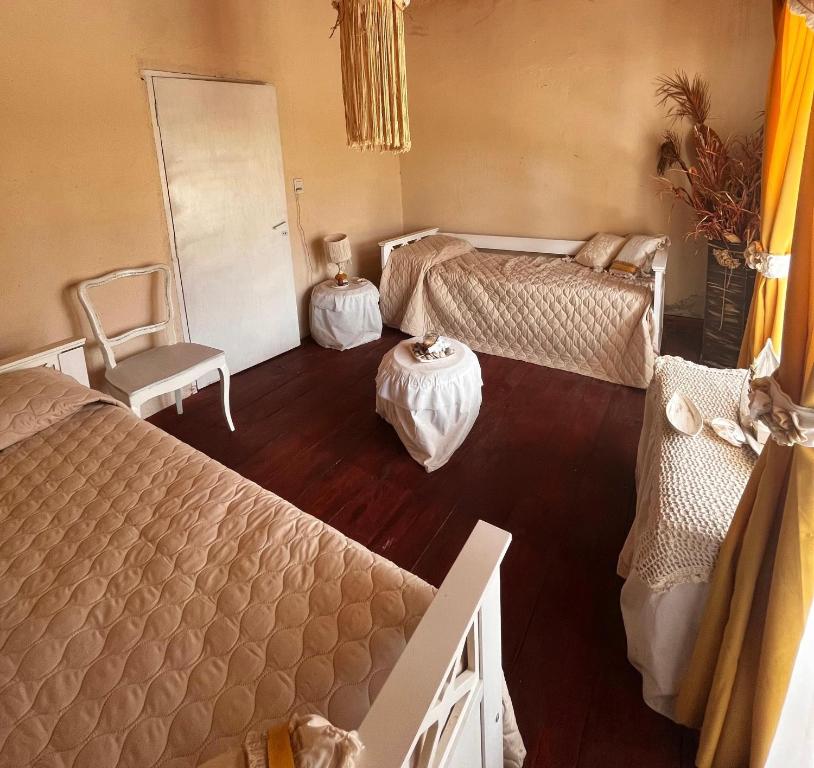 een slaapkamer met twee bedden en een tafel en een stoel bij La Cholita in Belén