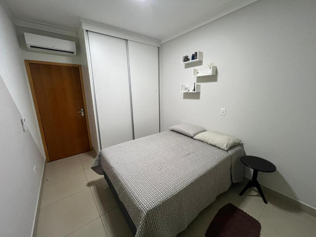 a bedroom with a bed and a stool in it at Casa nova e aconchegante in Americana