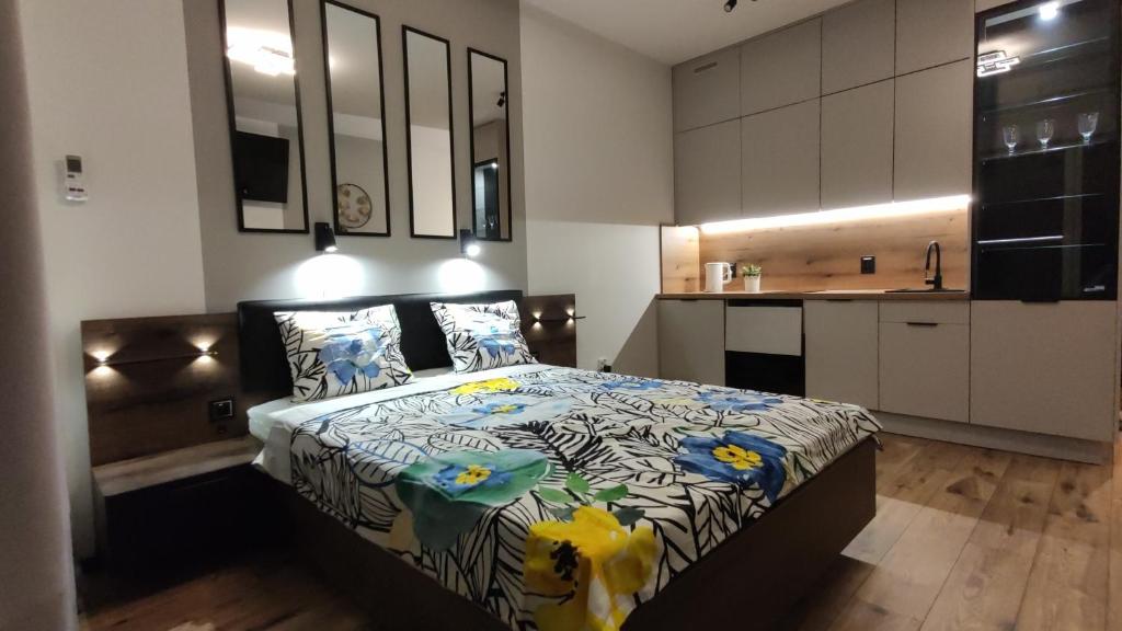 a bedroom with a bed and a kitchen at One-room apartment Nyska Residence Free garage!!! in Wrocław