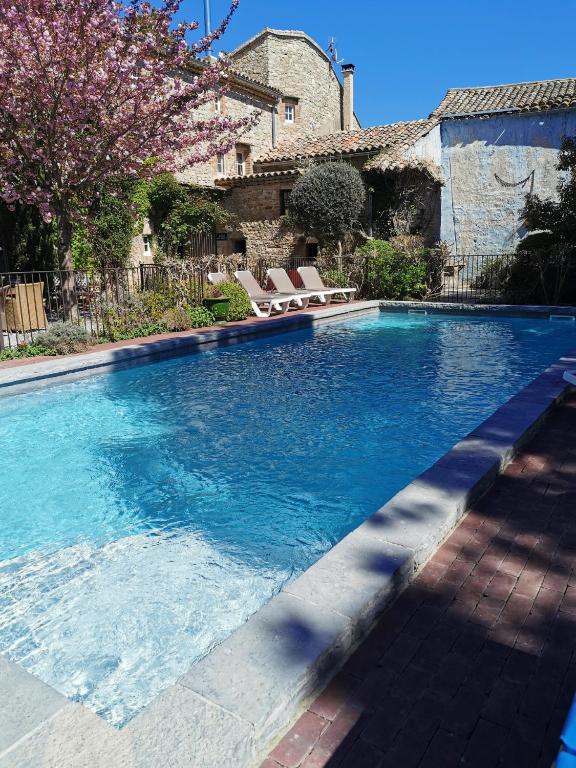 une piscine avec de l'eau bleue dans une cour dans l'établissement Vacances chez l'antiquaire 15 personnes 10 chambres, à Saint-Césaire-de-Gauzignan