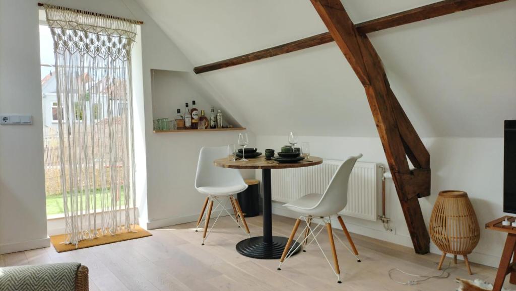 a dining room with a table and white chairs at Bovenste appartement in Middelburg