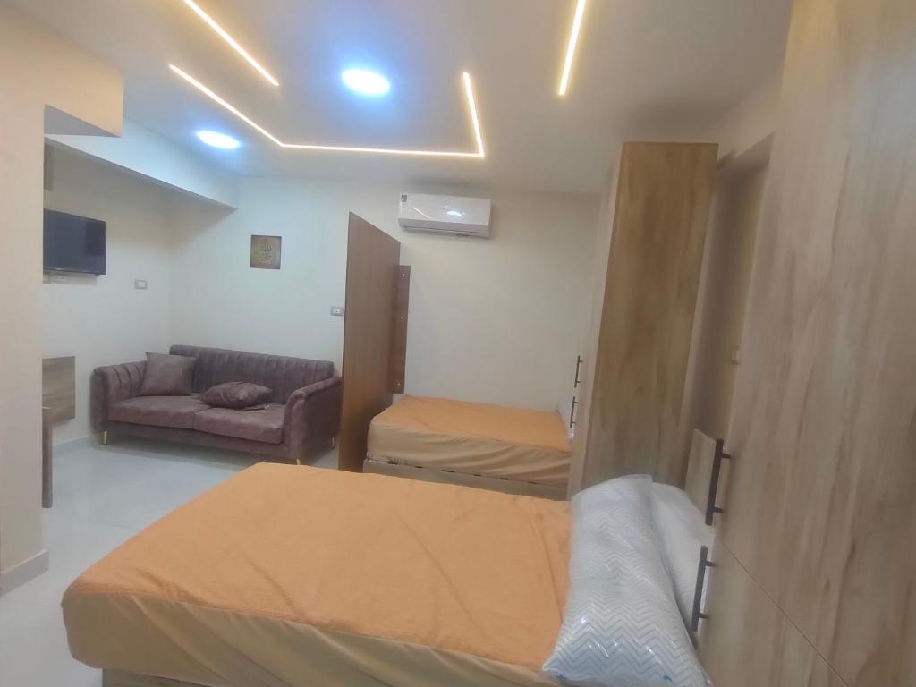 Una habitación con dos camas y un sofá. en استديو فاخر للايجار, en Seis de Octubre