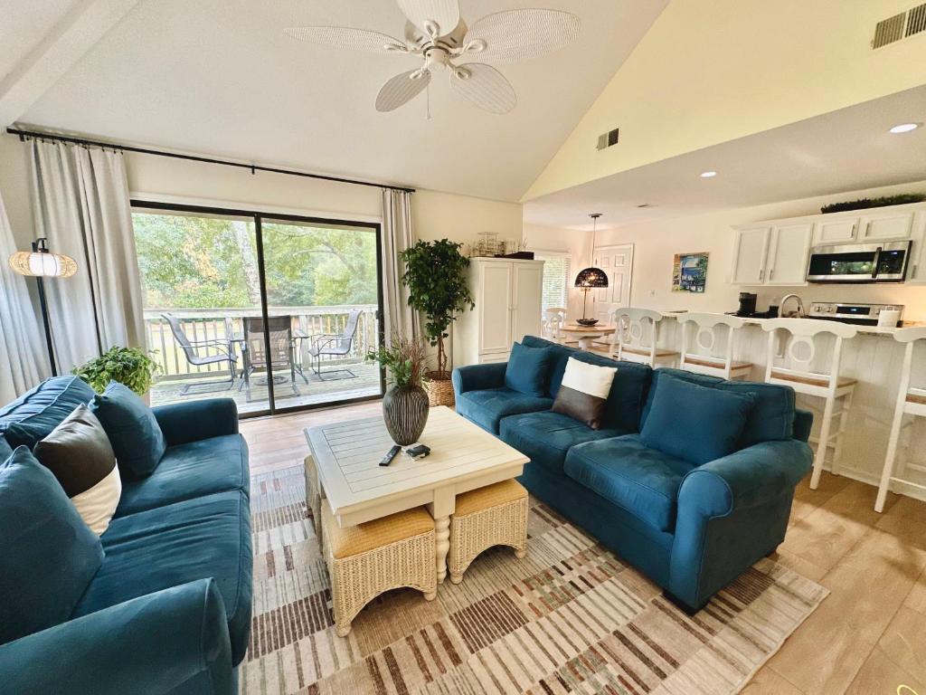 un salon avec des canapés bleus et une cuisine dans l'établissement Golf/ Beach Penthouse Condo, à Sunset Beach