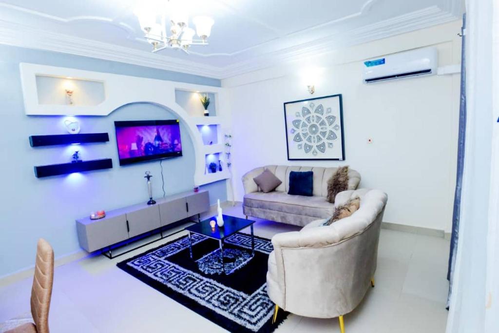 a living room with a couch and a tv at Résidence Le Prestige in Yaoundé