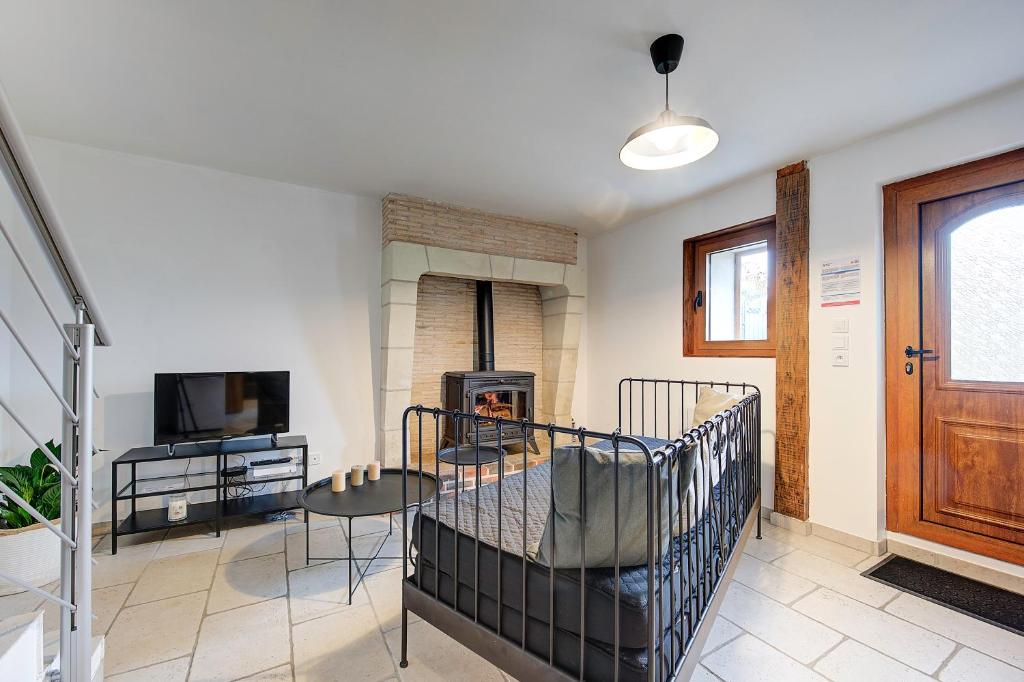 - un lit bébé dans une chambre avec cheminée dans l'établissement Le Refuge d'Azay, à Azay-sur-Cher