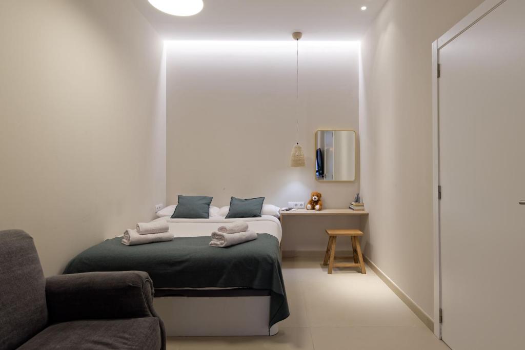 a bedroom with a bed and a chair and a mirror at Osito Hub - Esteban Ballester in Valencia