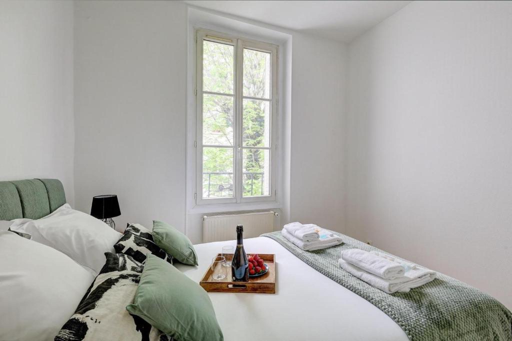 - une chambre blanche avec un lit et un plateau dans l'établissement Le Bellanger - Duplex tout équipé proche Paris, à Levallois-Perret