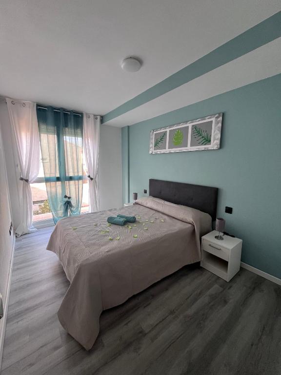a bedroom with a large bed and a large window at Mariposa in El Médano