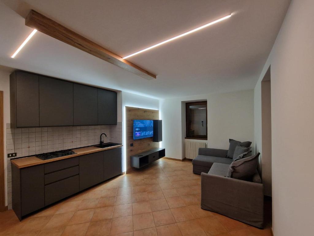 ein Wohnzimmer mit einer Küche und einem Sofa in der Unterkunft Villa Emma in Ponte di Legno