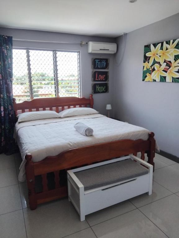 a bedroom with a large wooden bed and a window at Survivour Home in Nadi