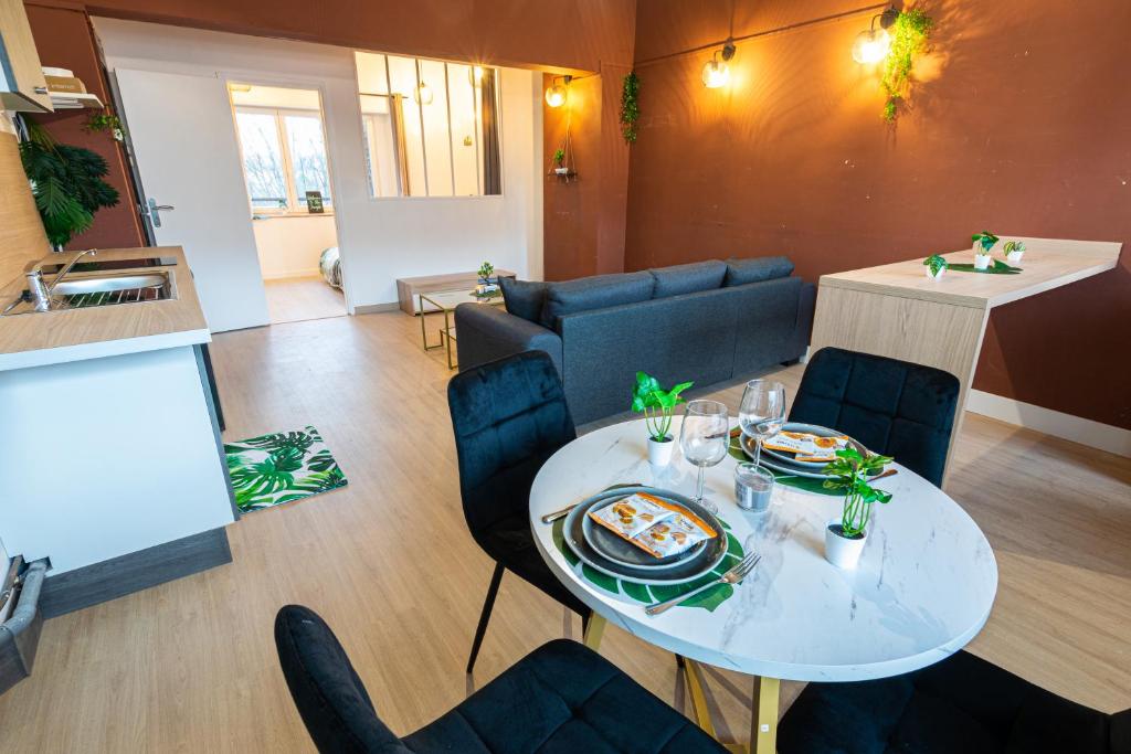 un salon avec une table et des chaises blanches dans l'établissement A 100 M DE LA VIELLE VILLE, PROCHE REMPARTS, cosy holiday, à Boulogne-sur-Mer