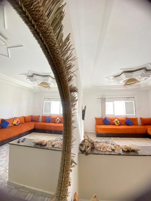 a living room with a couch and a palm tree at Tarbouche on the Beach in Essaouira