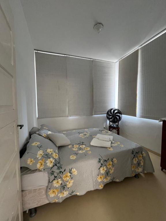 1 dormitorio con 1 cama con manta y almohadas en Casa Estrela Room, en Salvador
