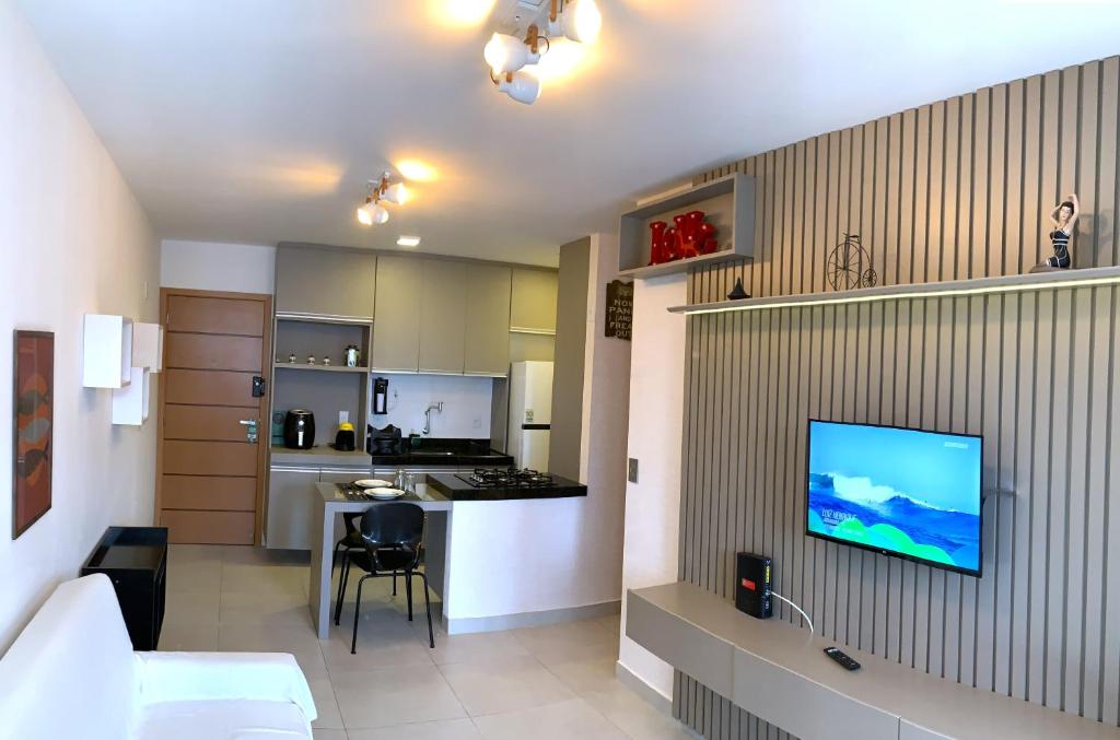 une cuisine et un salon avec une télévision au mur dans l'établissement Ponta Verde 250m praia I Feirinha do Artesanato I Piscina I Academia, à Maceió