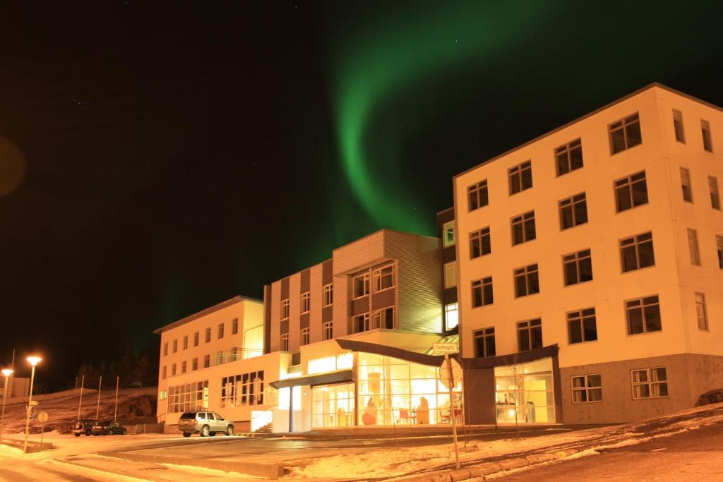 um edifício de apartamentos com as luzes do norte no céu em Hótel Borgarnes em Borgarnes