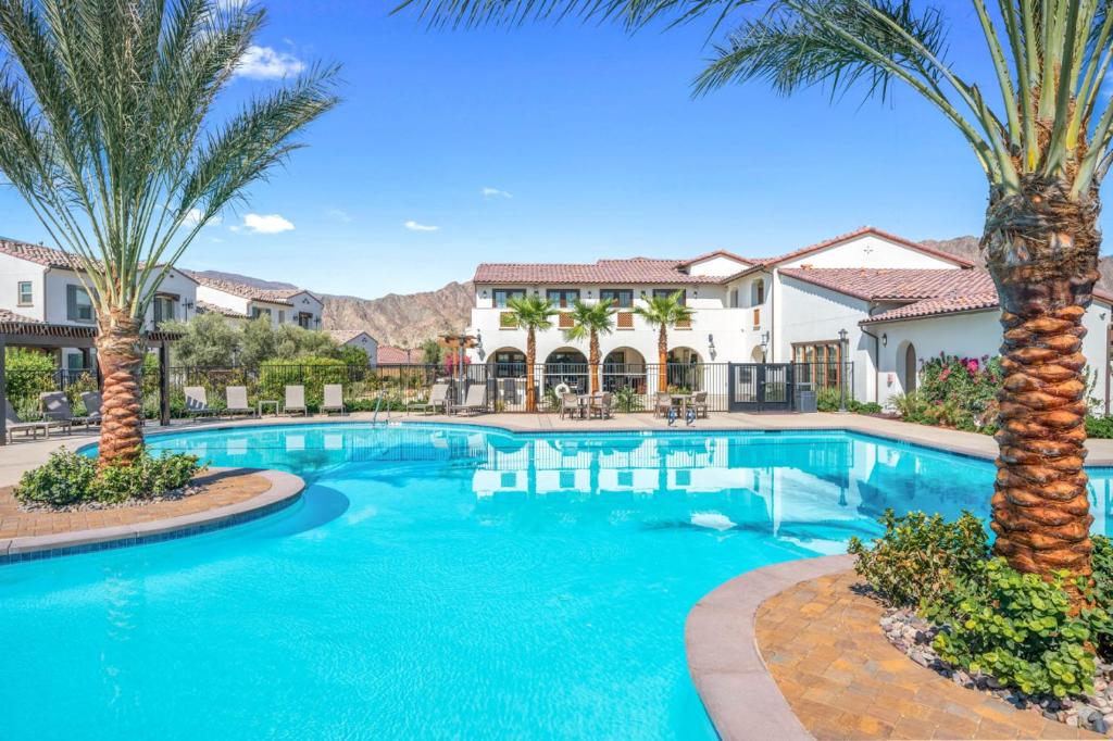 una piscina con palmeras y edificios en Luxury and comfort throughout Pool Spa Putting Green, en La Quinta