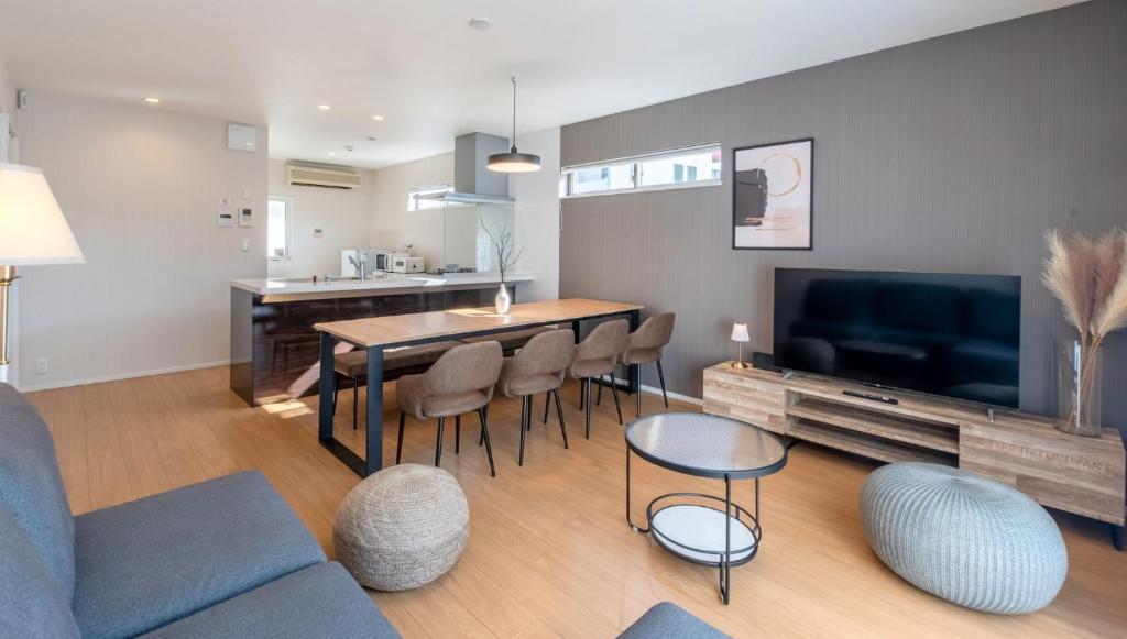 a living room with a table and chairs and a tv at Villa RIKUNOYA SUZUKA in Suzuka