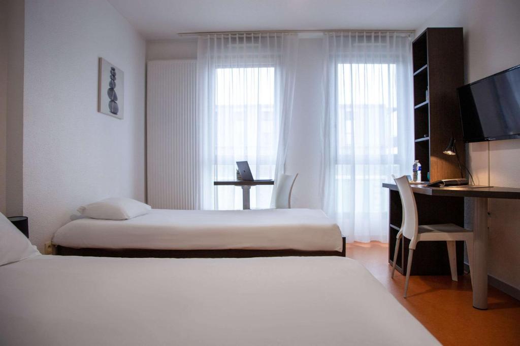 Postel nebo postele na pokoji v ubytování Comfort Aparthotel Besancon Hauts du Chazal