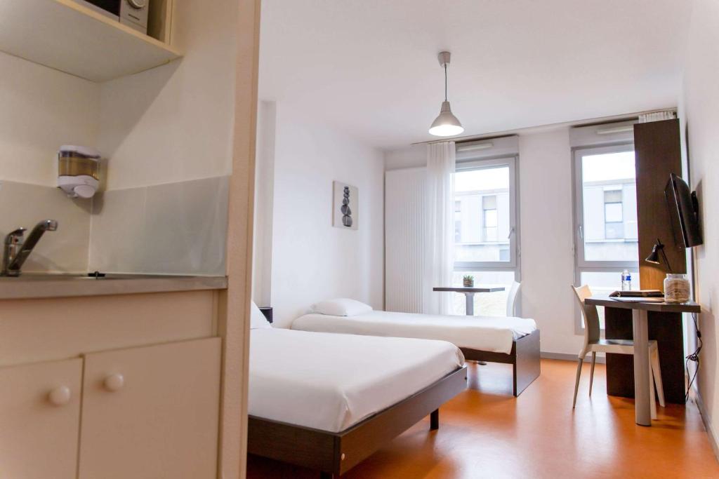 Postel nebo postele na pokoji v ubytování Comfort Aparthotel Besancon Hauts du Chazal