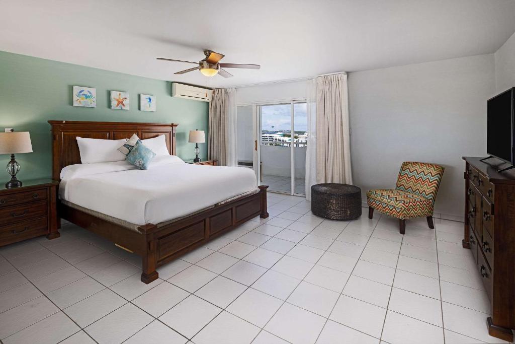 シンプソン・ベイにあるThe Atrium Beach Resort and Spa, Ascend Hotel Collectionのベッドルーム(ベッド1台、テレビ、椅子付)