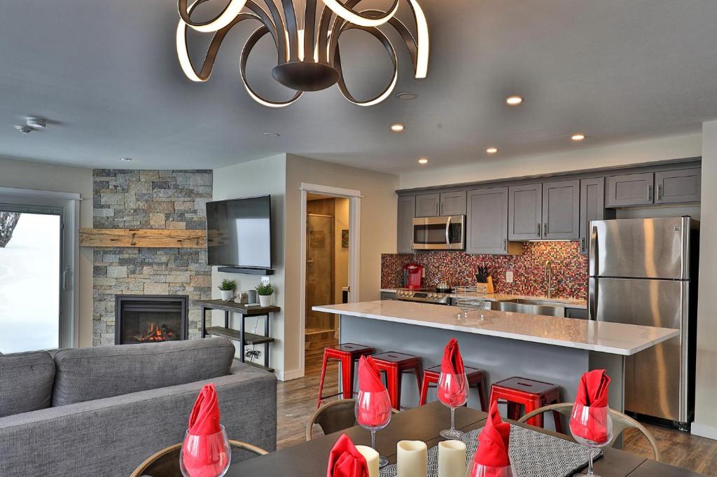 a kitchen and a living room with red bows at The Forest Fun Suite - 2RM-2BA Condo, Pool, Bus, King Bed, 2 Sofa Beds, Fireplace, Ski Rental Deals in Killington
