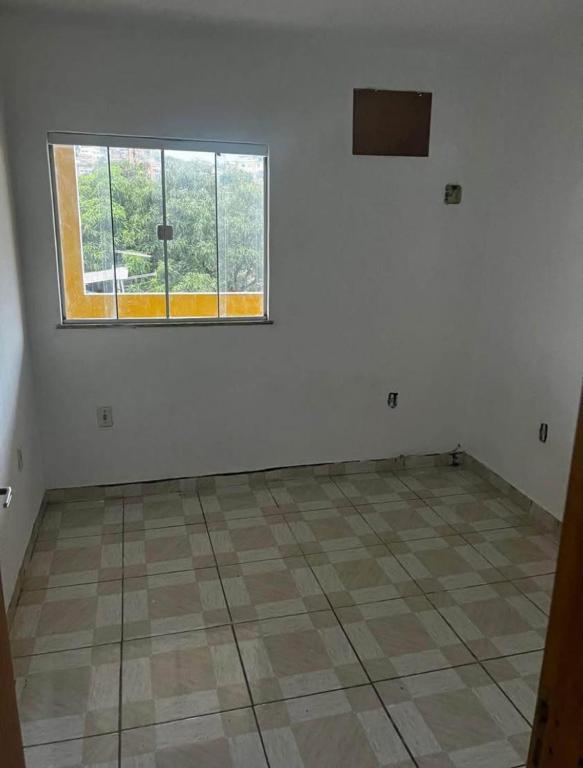 an empty room with a window and a tiled floor at Confort Casa in São João de Meriti
