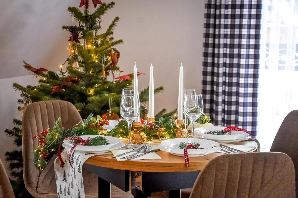 a dining room table with a christmas tree in the background at Cicha Woda 300 m od Gorący Potok i Termy Szaflary in Szaflary