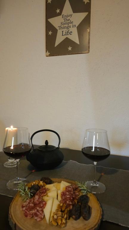 a table with two glasses of wine and a plate of food at Studio apartment Cami - Cottage with a soul in Gračišće