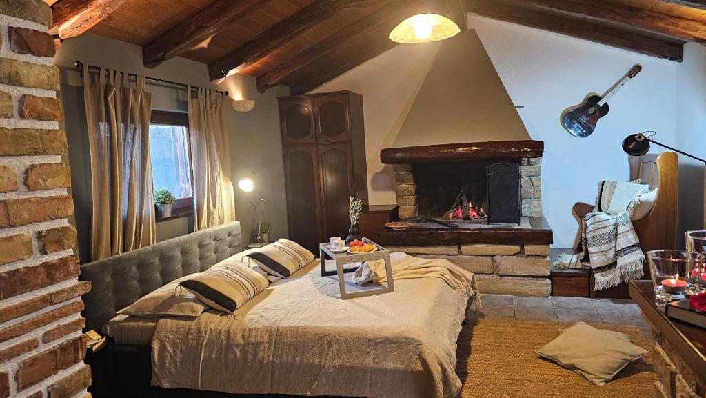 a bedroom with a bed with a fireplace and a guitar at Studio apartment Cami - Cottage with a soul in Gračišće