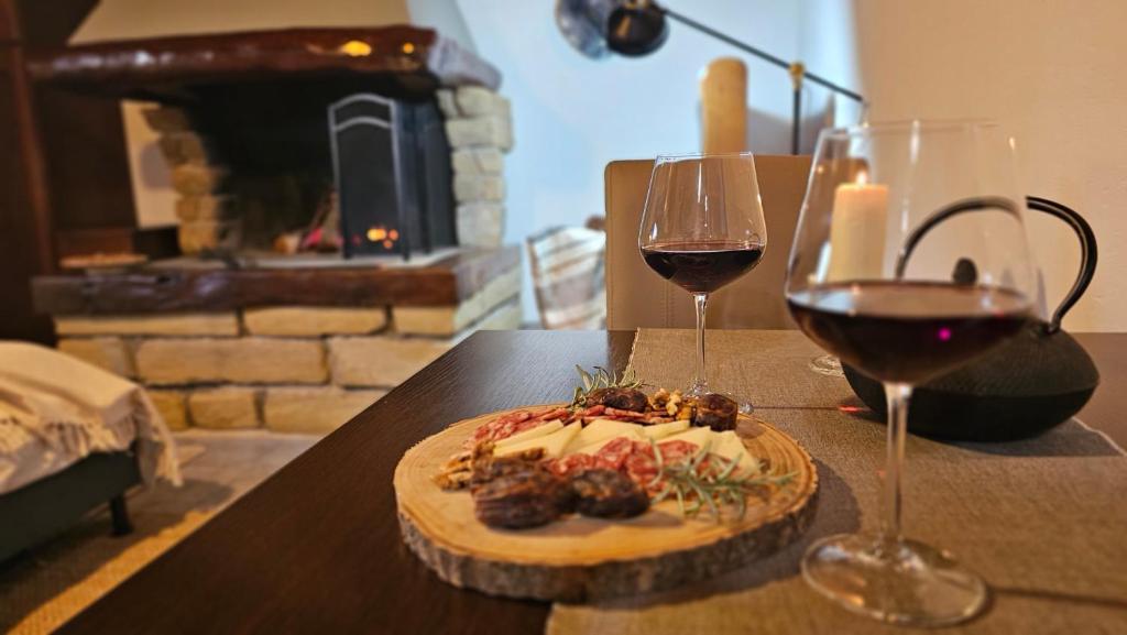 a table with a cake and two glasses of wine at Studio apartment Cami - Cottage with a soul in Gračišće