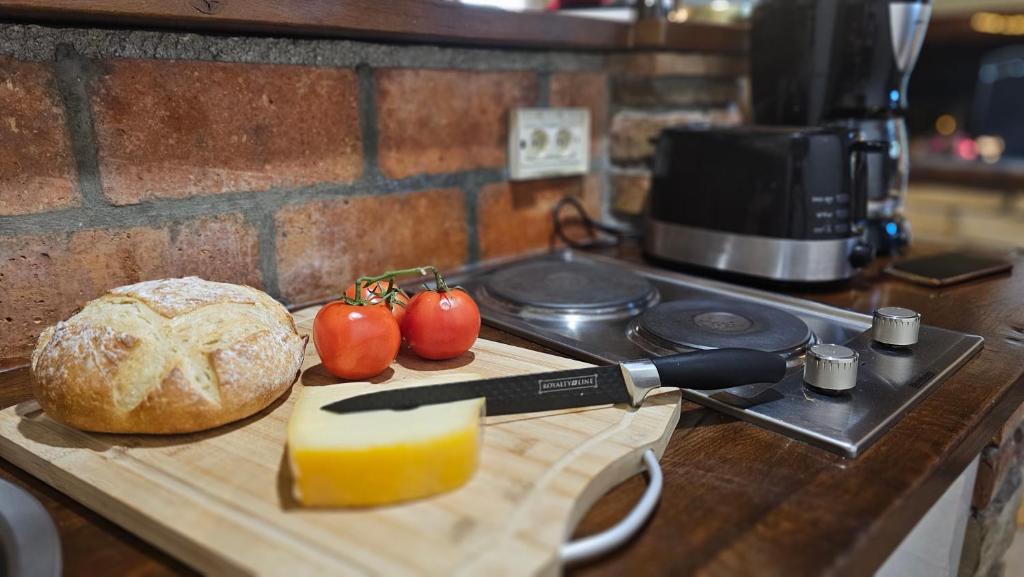 a cutting board with a knife and tomatoes on a counter at Studio apartment Cami - Cottage with a soul in Gračišće