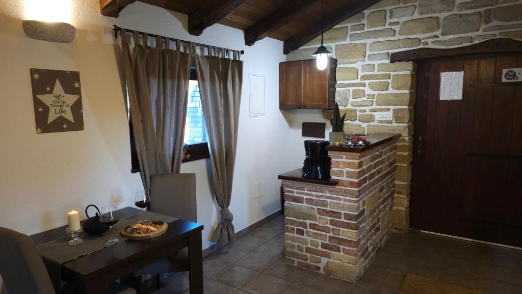 a living room with a table and a brick fireplace at Studio apartment Cami - Cottage with a soul in Gračišće