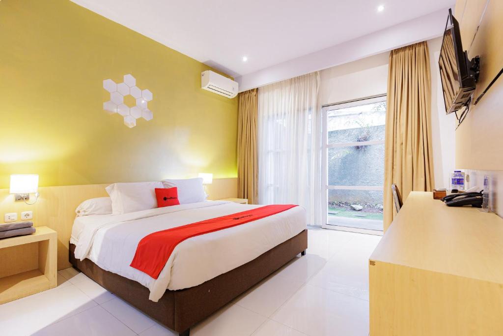 a bedroom with a large bed and a window at RedDoorz Plus Syariah near Museum Lampung in Kedaton